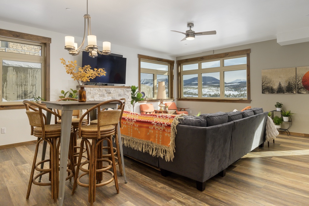 Gather around your spacious living area where plush seating meets stunning mountain views through expansive windows, creating the perfect backdrop for memorable evenings.
