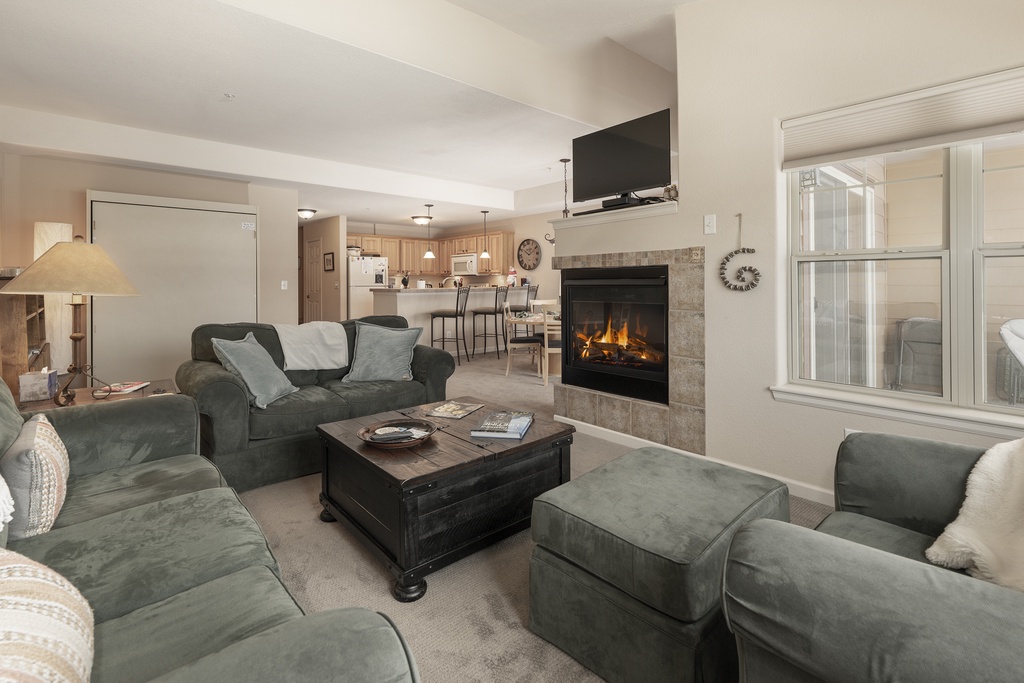 Unwind in your spacious living room with plush seating around a cozy fireplace, creating the perfect atmosphere for relaxation.