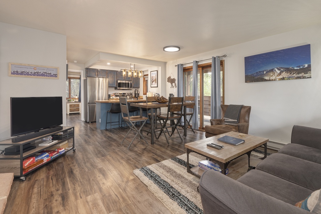 Relax in your open-plan living space with mountain views, modern kitchen, and comfortable seating for memorable moments.