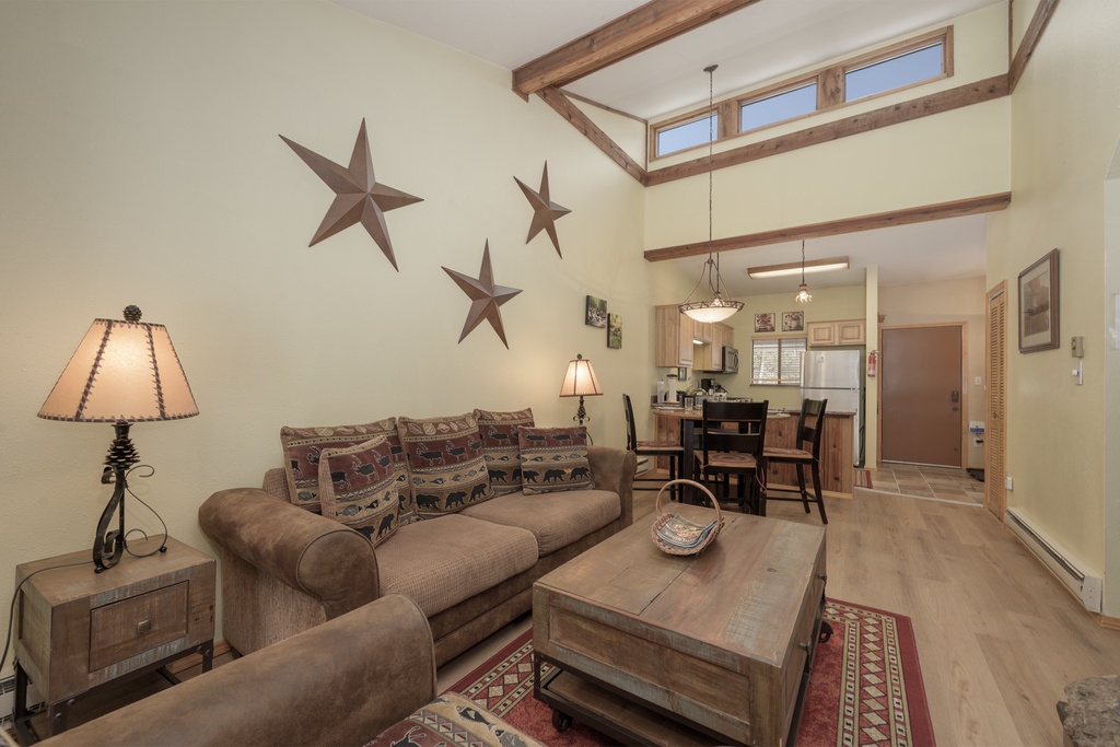 Relax in your rustic retreat with exposed beams, cozy seating, and western charm throughout this open-plan living space.