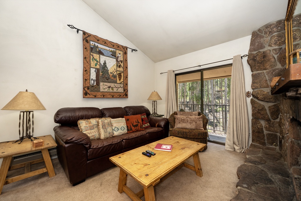 Sink into the plush leather sofa by your cozy stone fireplace, where rustic charm meets mountain comfort in your perfect retreat.