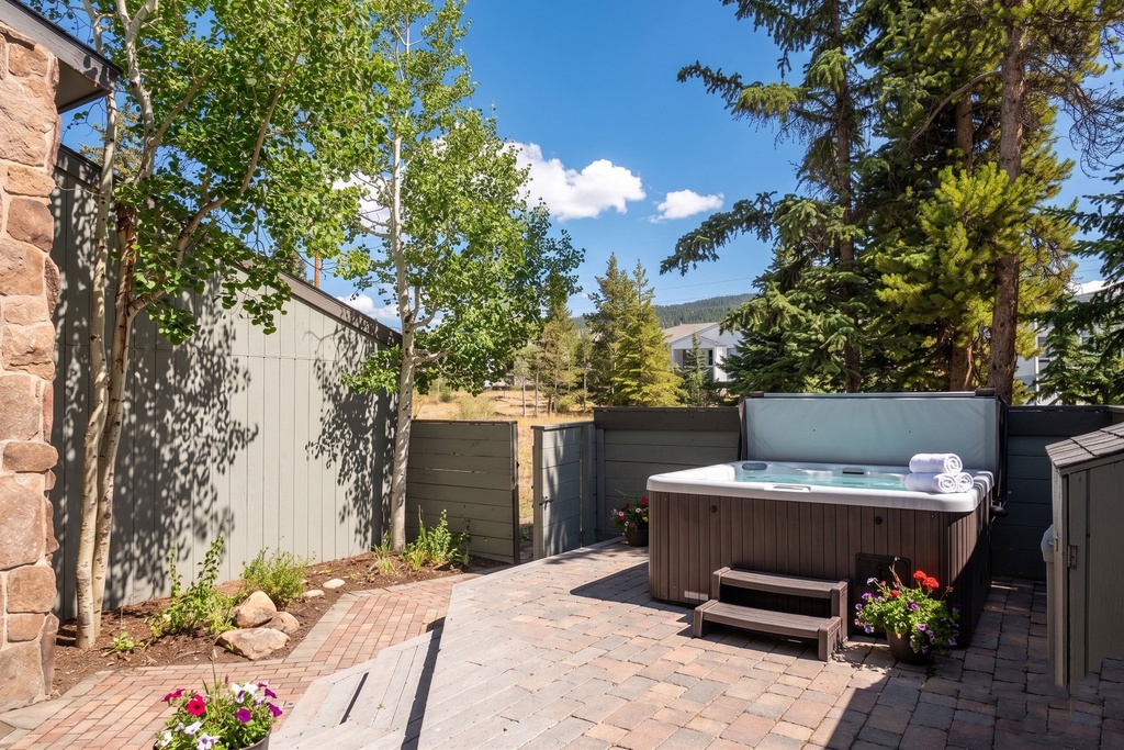 Slip into your private hot tub surrounded by towering pines and mountain views—your perfect retreat after a day of adventure.