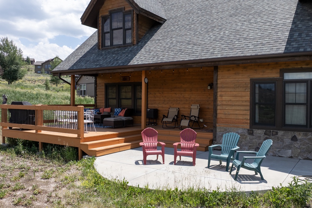 Charming mountain cabin with spacious deck and colorful Adirondack chairs for your perfect outdoor retreat.