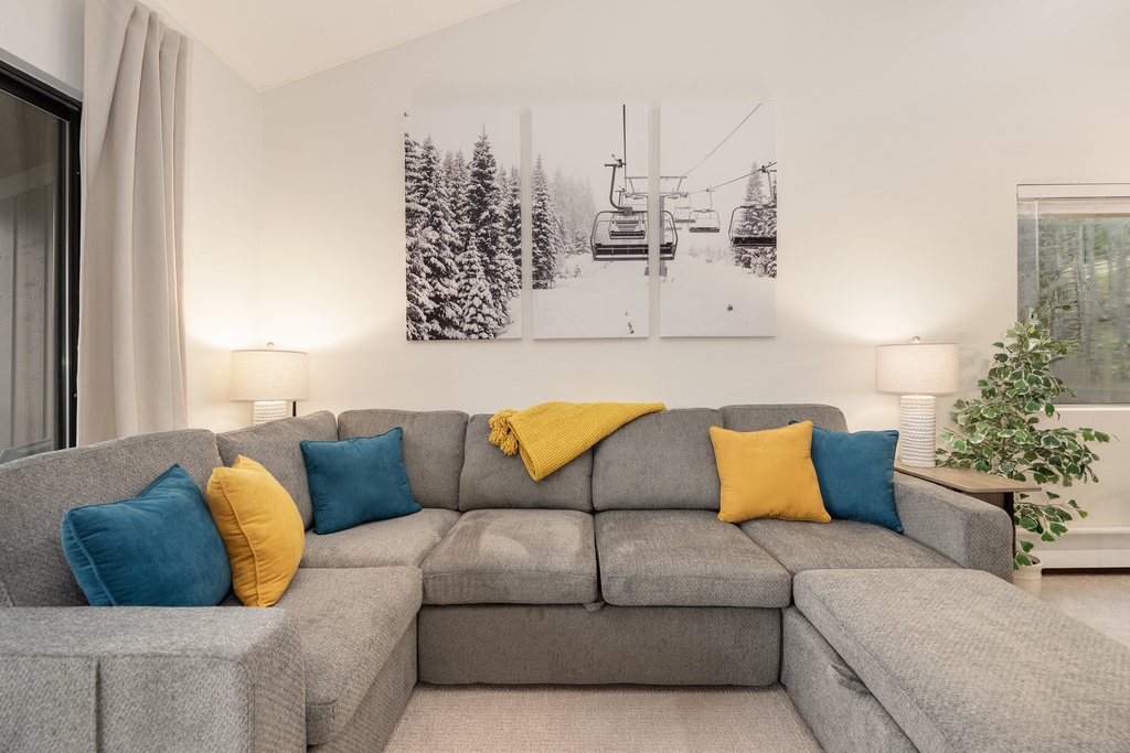 Sink into this plush sectional with vibrant pillows and unwind beneath mountain-inspired art after your alpine adventures.