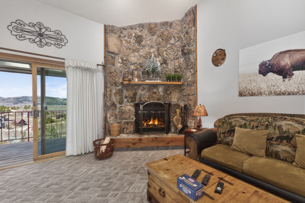 Cozy up by your crackling stone fireplace while taking in mountain views from your private balcony—perfect for unwinding after adventure-filled days.