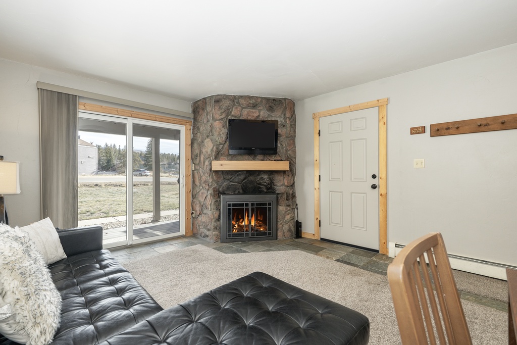 Cozy up by your crackling stone fireplace while watching TV, with mountain views through sliding doors beckoning you outside.