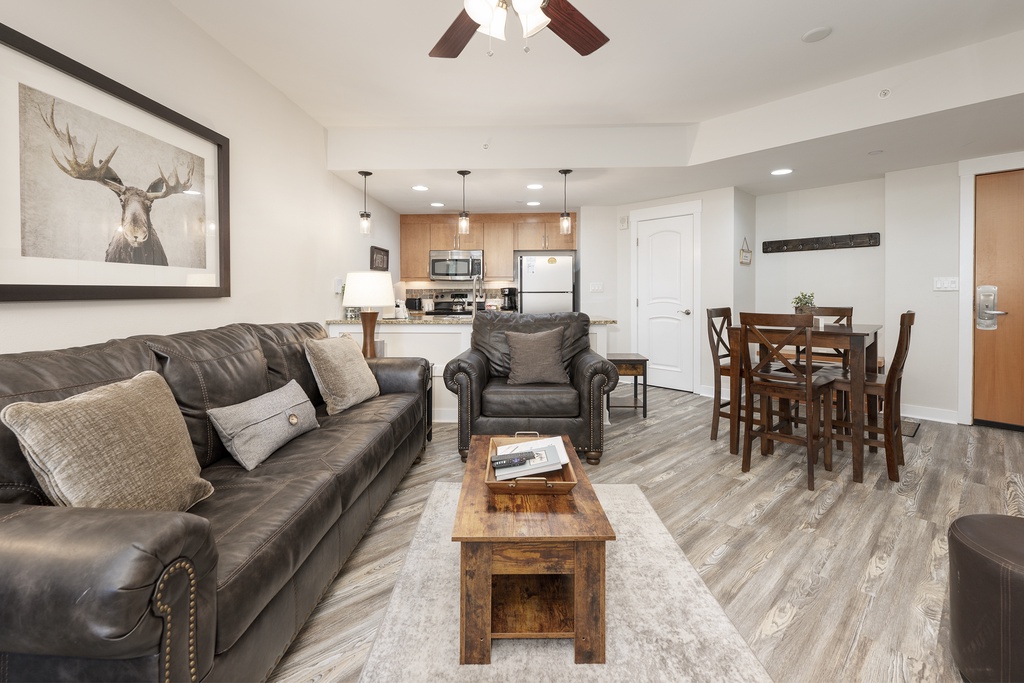 Relax in your stylish open-concept space with rich leather seating, rustic wood accents, and a fully equipped kitchen perfect for home-cooked meals.