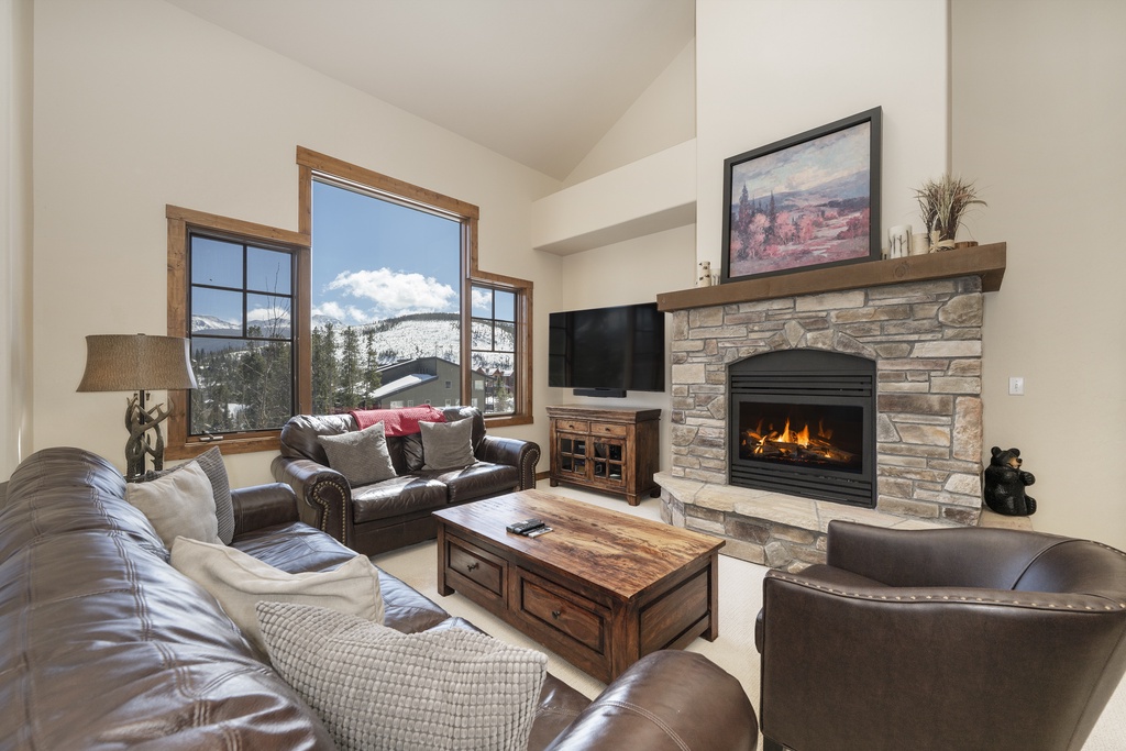 Cozy up in your living room with mountain views, crackling fireplace, and luxurious leather seating perfect for après-ski relaxation.