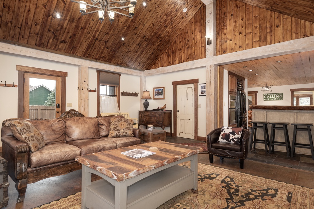 Relax in your rustic mountain retreat with soaring timber ceilings, leather seating, and western charm throughout this cozy living space.