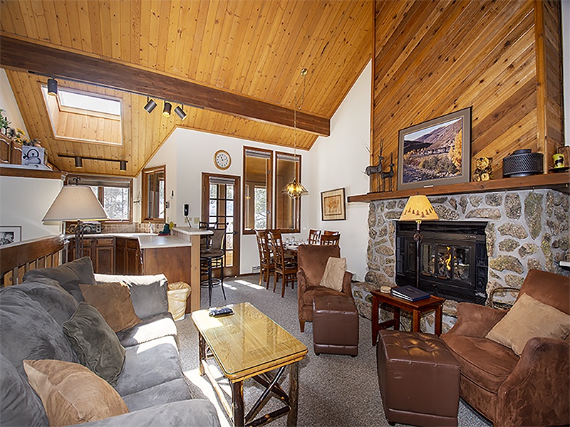 Unwind in your cozy mountain retreat with vaulted wood ceilings, stone fireplace, and comfortable seating where rustic charm meets modern comfort.