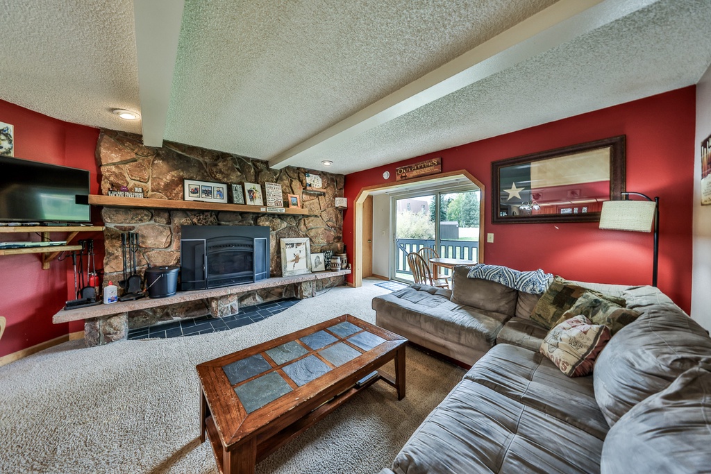 Cozy up in your spacious living room with plush leather seating, warming fireplace, and entertainment center for perfect mountain retreat evenings.