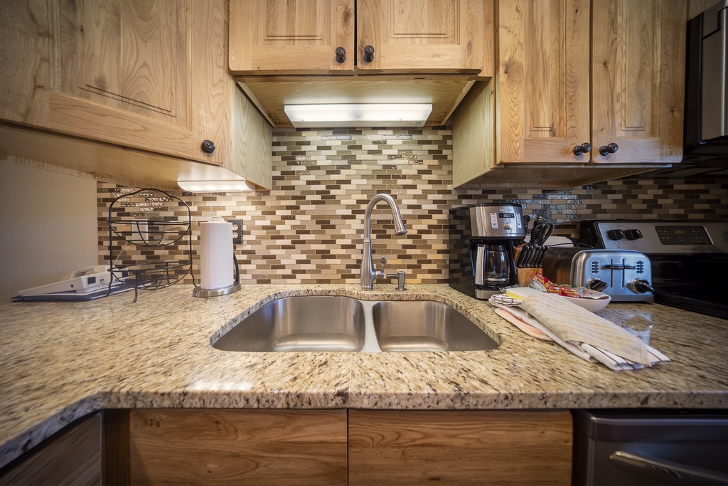 Your fully equipped kitchen awaits with granite counters, stainless appliances, and warm wood cabinets—perfect for preparing meals together.