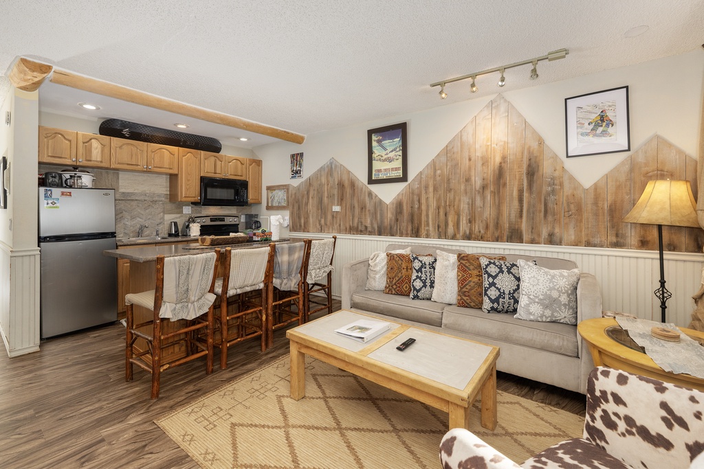 Unwind in your cozy mountain retreat with rustic wood accents, a fully equipped kitchen, and comfortable seating perfect for après-ski relaxation.