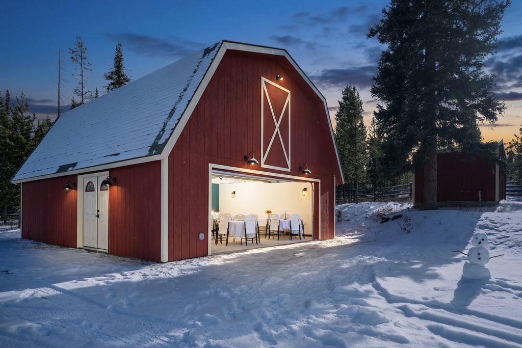 Charming red barn nestled among snow-covered pines, featuring a cozy dining area with rustic mountain charm and winter wonderland setting.