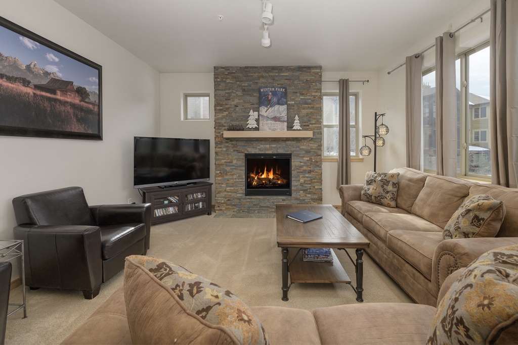 Cozy up by the crackling fireplace while watching your favorite shows on the large flat-screen TV in this welcoming living room.