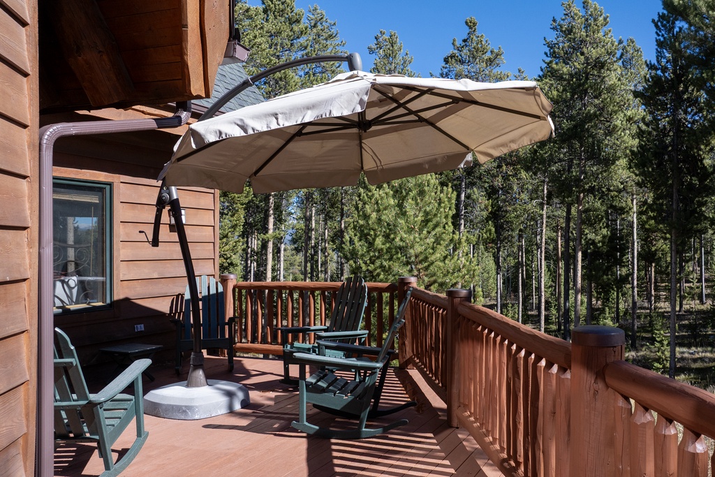 Relax on your private deck surrounded by towering pines. Comfortable seating and shade umbrella create your perfect outdoor retreat.