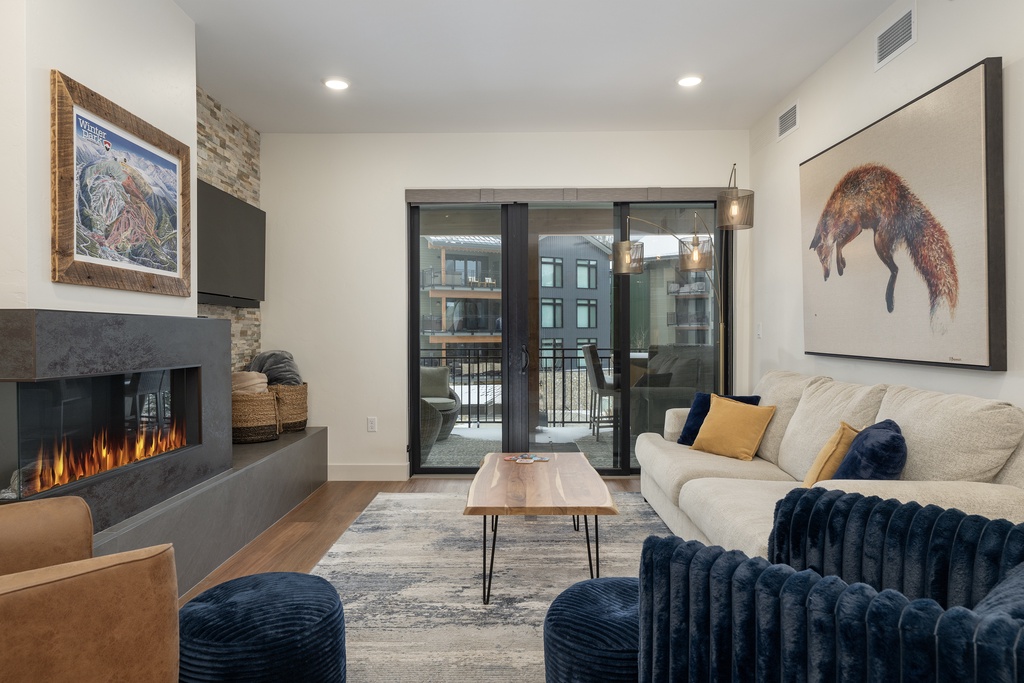 Unwind in your contemporary living room, where a modern fireplace creates warmth while you relax on plush seating overlooking the city.