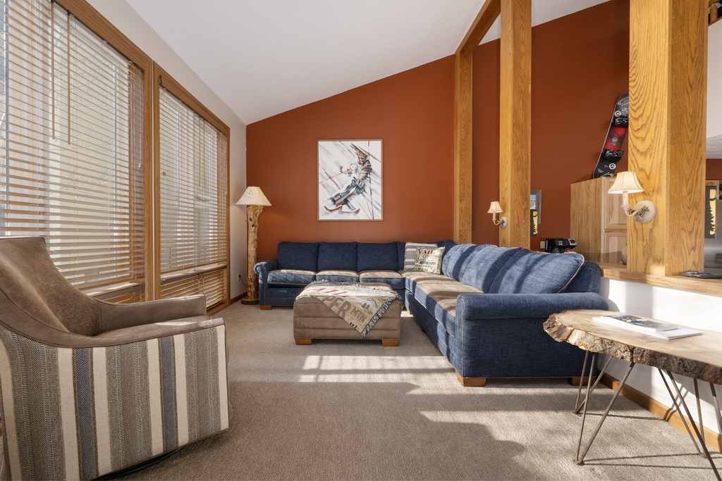Sink into this cozy living room where warm wood beams and a plush sectional create your perfect mountain retreat atmosphere.