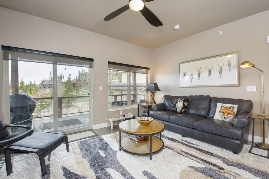 Relax in your bright living room with leather seating, ceiling fan comfort, and private balcony access overlooking the neighborhood.