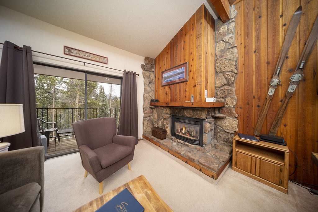 Warm up by your stone fireplace in this cozy mountain retreat, with rustic wood walls and serene forest views from your private balcony.