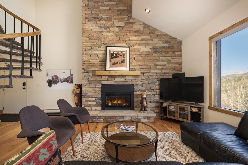 Cozy up by your stone fireplace while mountain views stretch beyond the windows in this stylish living room.