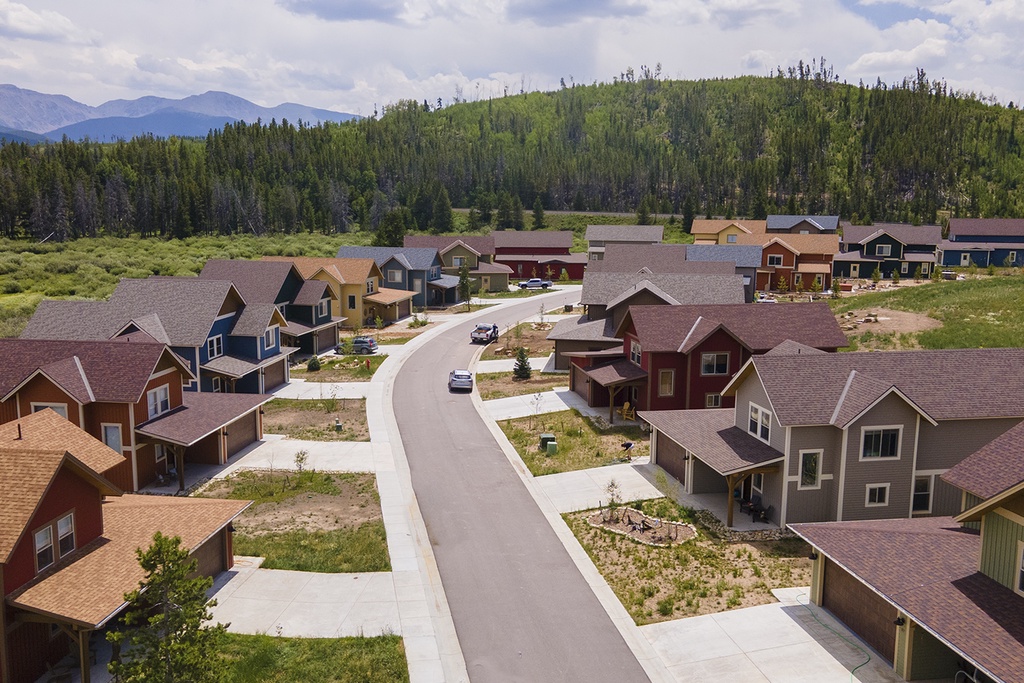 Mountain resort community nestled among forested hills, featuring diverse vacation homes with private driveways and scenic natural surroundings.