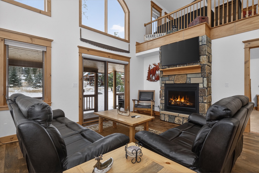 Sink into plush leather recliners by your crackling stone fireplace, where soaring ceilings and mountain views create your perfect alpine retreat.