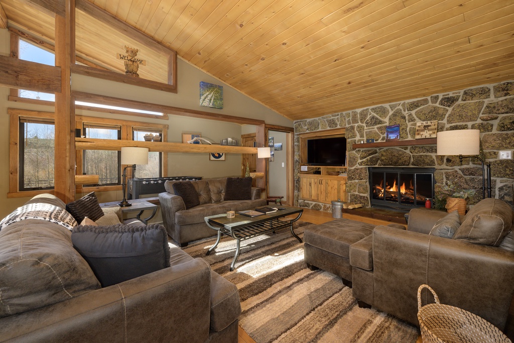 Sink into plush seating beside your crackling stone fireplace, where warm wood beams and mountain views create your perfect retreat.