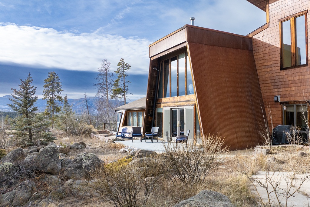 Modern mountain retreat with stunning architecture blending seamlessly into the natural landscape and scenic mountain backdrop.