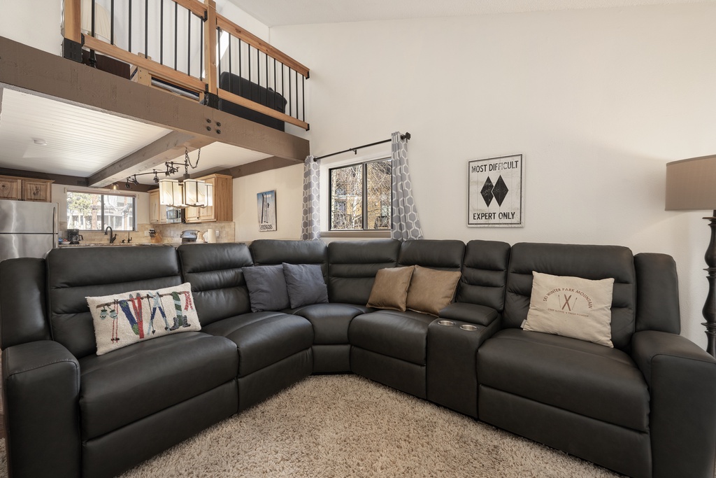 Sink into this spacious leather sectional where you can unwind after your mountain adventures, with the loft above adding cozy charm to your retreat.