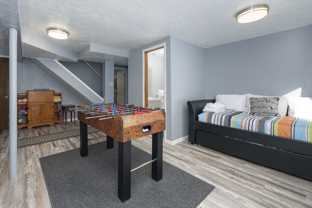 Your basement retreat at 874 Kinnikinnick Road combines relaxation and fun with a foosball table for friendly matches and comfortable seating for movie nights.