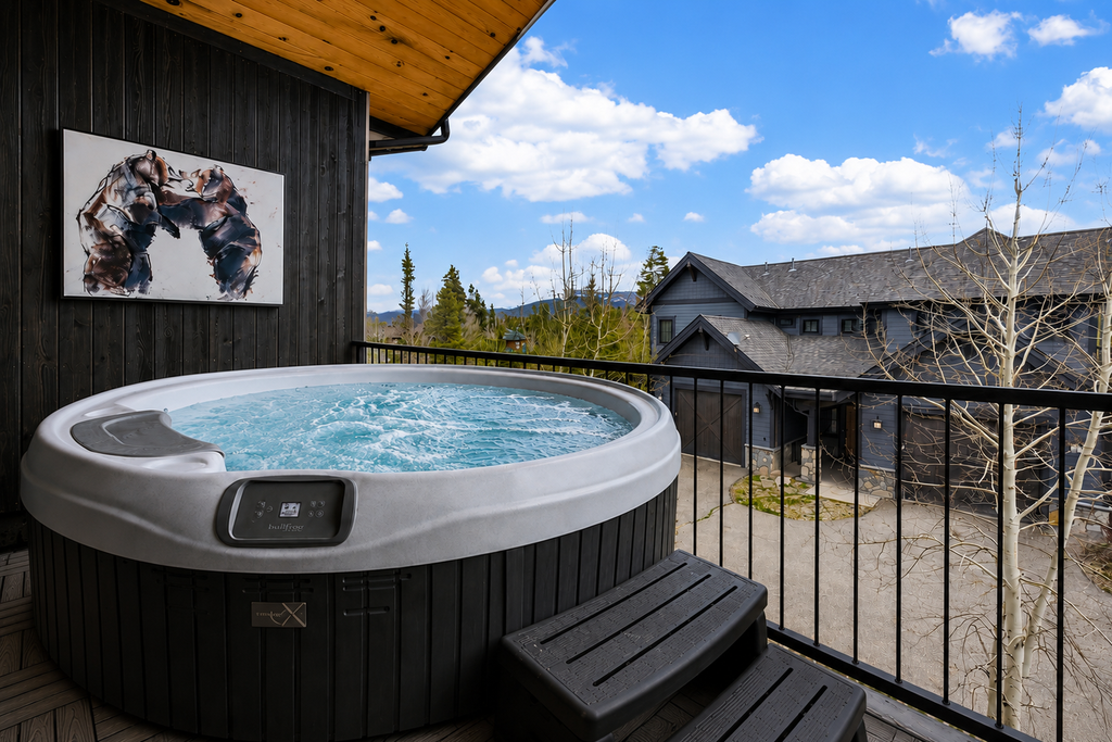 Soak away your cares in your private hot tub on the deck, surrounded by lush forest and mountain views under clear blue skies.