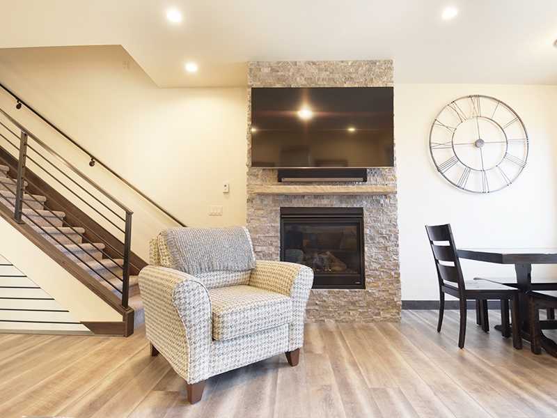 Unwind in your stylish living space featuring a cozy fireplace, modern amenities, and warm wood floors perfect for relaxing evenings.
