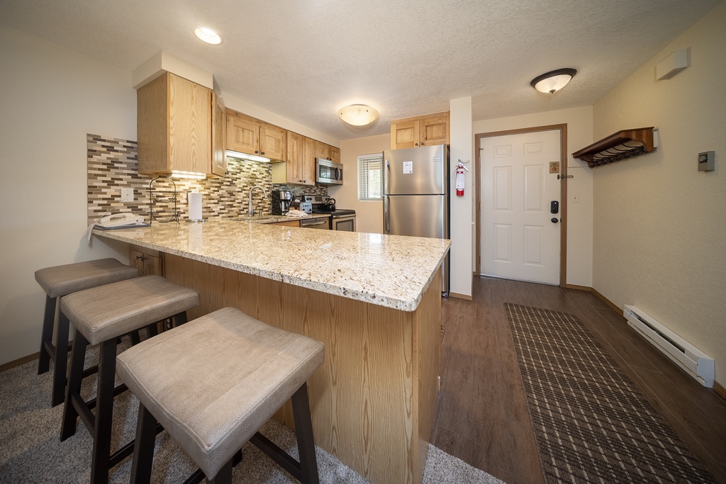 Your fully equipped kitchen features granite countertops, modern appliances, and a breakfast bar where you can enjoy morning coffee.