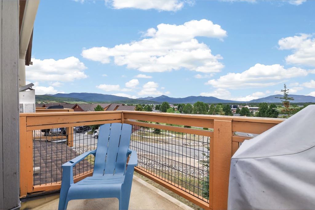The property features a balcony offering sweeping mountain vistas, lush greenery, and clear blue skies—a peaceful arrival setting framed by scenic natural surroundings.