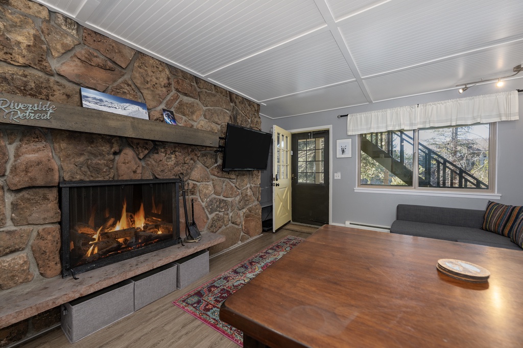 Cozy up by your crackling stone fireplace while watching TV in this inviting living space with rustic charm.