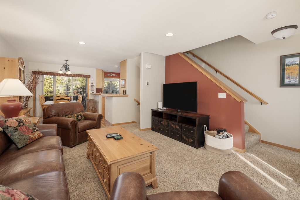 Sink into plush leather seating in your spacious living room, where warm colors and mountain views create the perfect retreat.