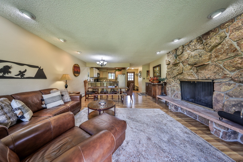 Unwind in this spacious open living area featuring rich leather seating and a stunning stone fireplace that creates the perfect gathering spot.