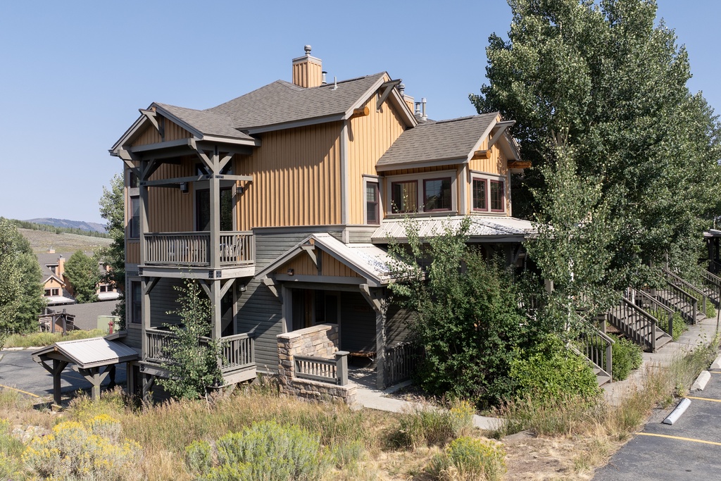 Kicking Horse Maverick 5-203 is a spacious mountain retreat with multi-level design and natural wood siding nestled among mature trees in a peaceful residential setting.