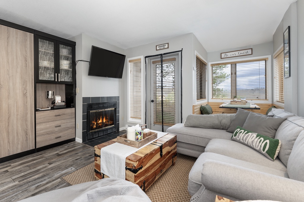 Unwind on plush gray sectionals by your crackling fireplace, where Colorado charm meets modern comfort in your cozy mountain retreat.