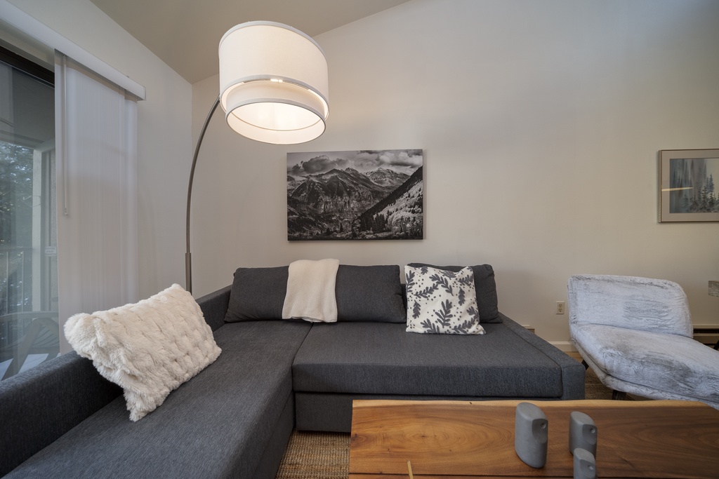 Sink into this plush sectional sofa and unwind in your stylish living room, perfectly lit by the modern arc lamp overhead.