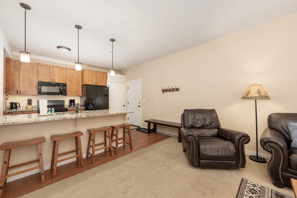 Relax in your spacious open-concept living area with granite countertops, full kitchen, and comfortable leather seating for memorable evenings.