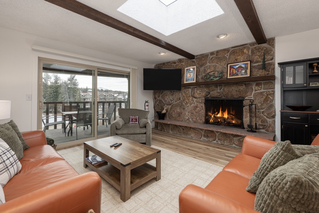 Cozy up by your crackling stone fireplace while soft light streams through the skylight above your comfortable leather seating area.