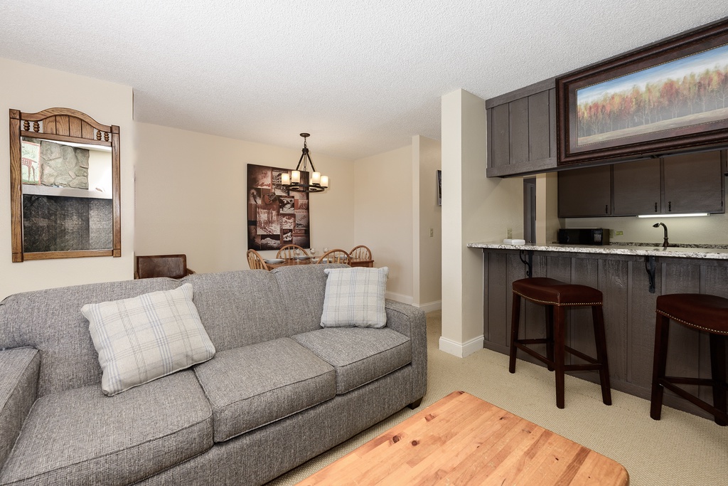 Unwind in your cozy living space with plush seating and a fully equipped kitchen for effortless mountain getaways.