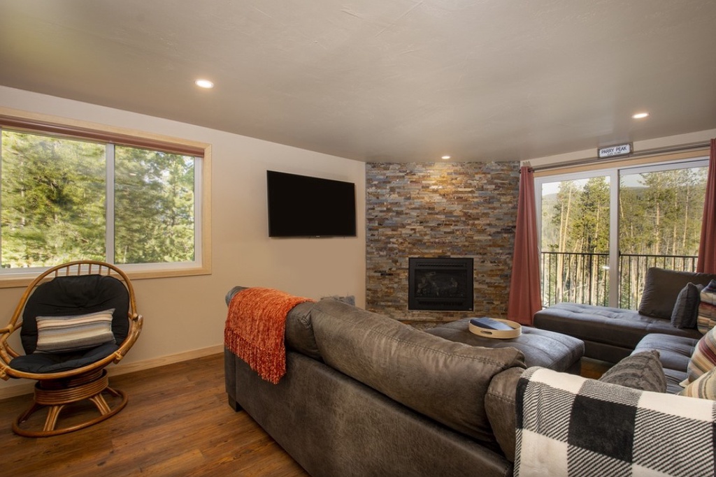 Cozy up by your stone fireplace while forest views surround this bright, modern retreat.