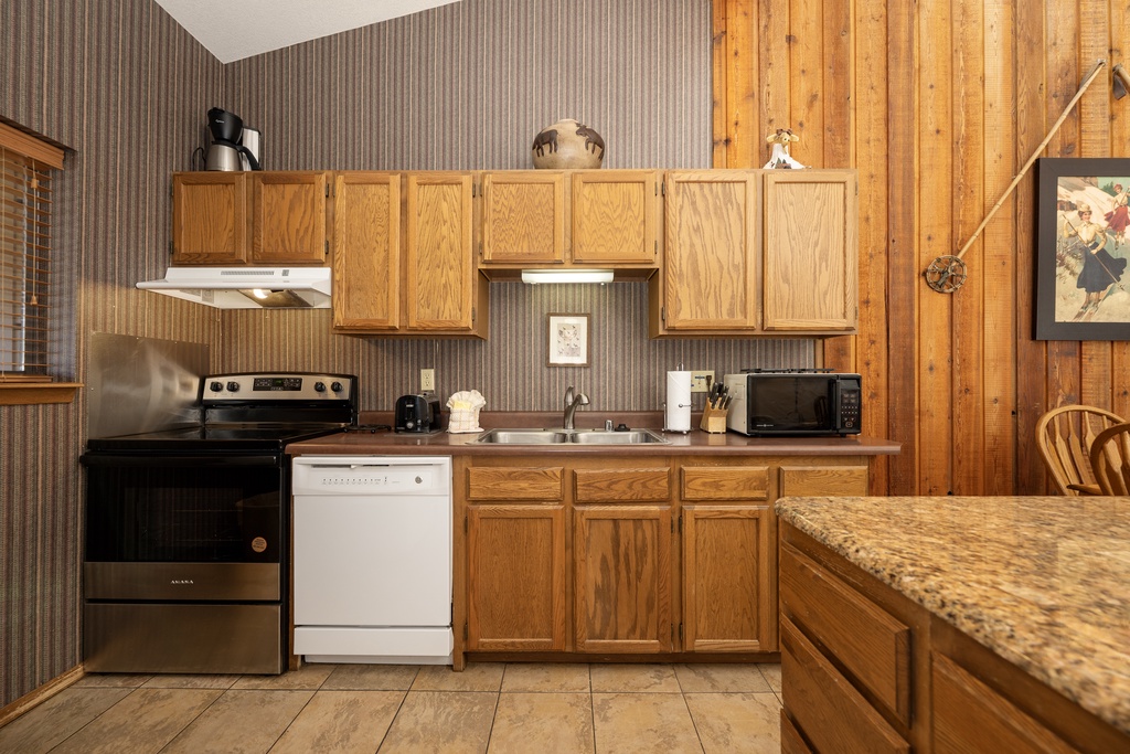 Your fully equipped kitchen features warm wood cabinetry, granite counters, and everything you need to prepare meals during your stay.