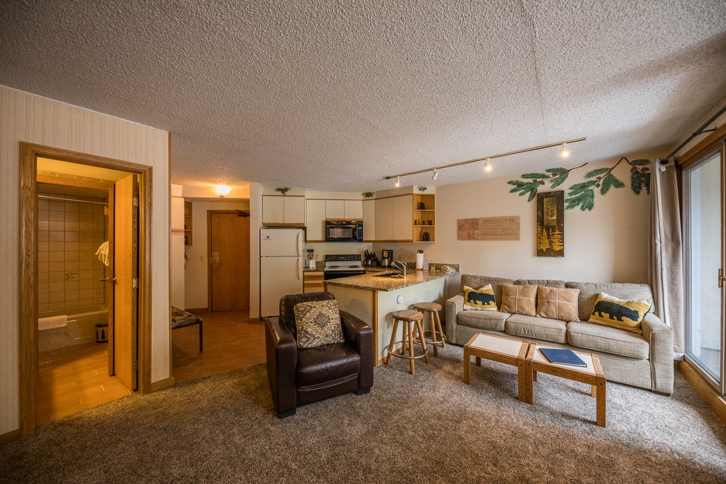 Cozy open-plan space where you'll relax on the comfortable sectional while preparing meals in your fully equipped kitchen.