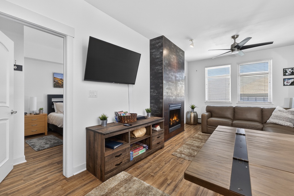 Sink into plush leather seating and feel the warmth of the fireplace glow across this bright, modern living space with vaulted ceilings and natural light.