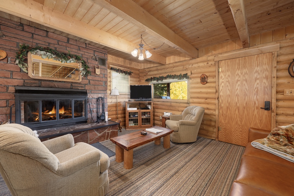 Cozy up in your rustic living room with crackling fireplace, exposed wood beams, and comfortable seating perfect for mountain evenings.
