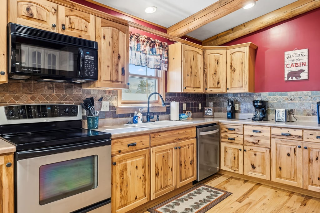 Your fully equipped cabin kitchen features rustic wood cabinets, modern appliances, and everything needed to cook memorable meals.